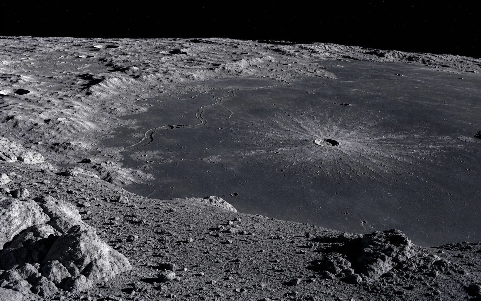 A detailed lunar surface showing craters, dark maria, regolith, and a rille.